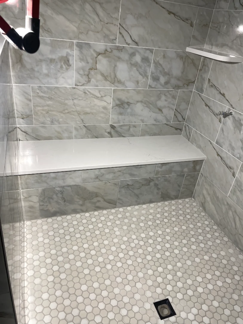 Finished marble shower with penny tile floor